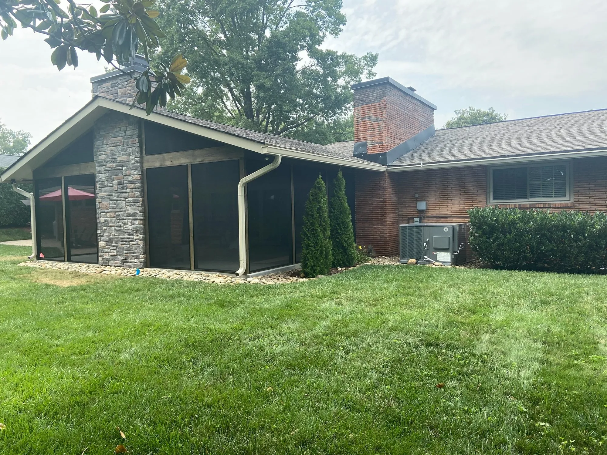 Screen porch addition with stone chimney