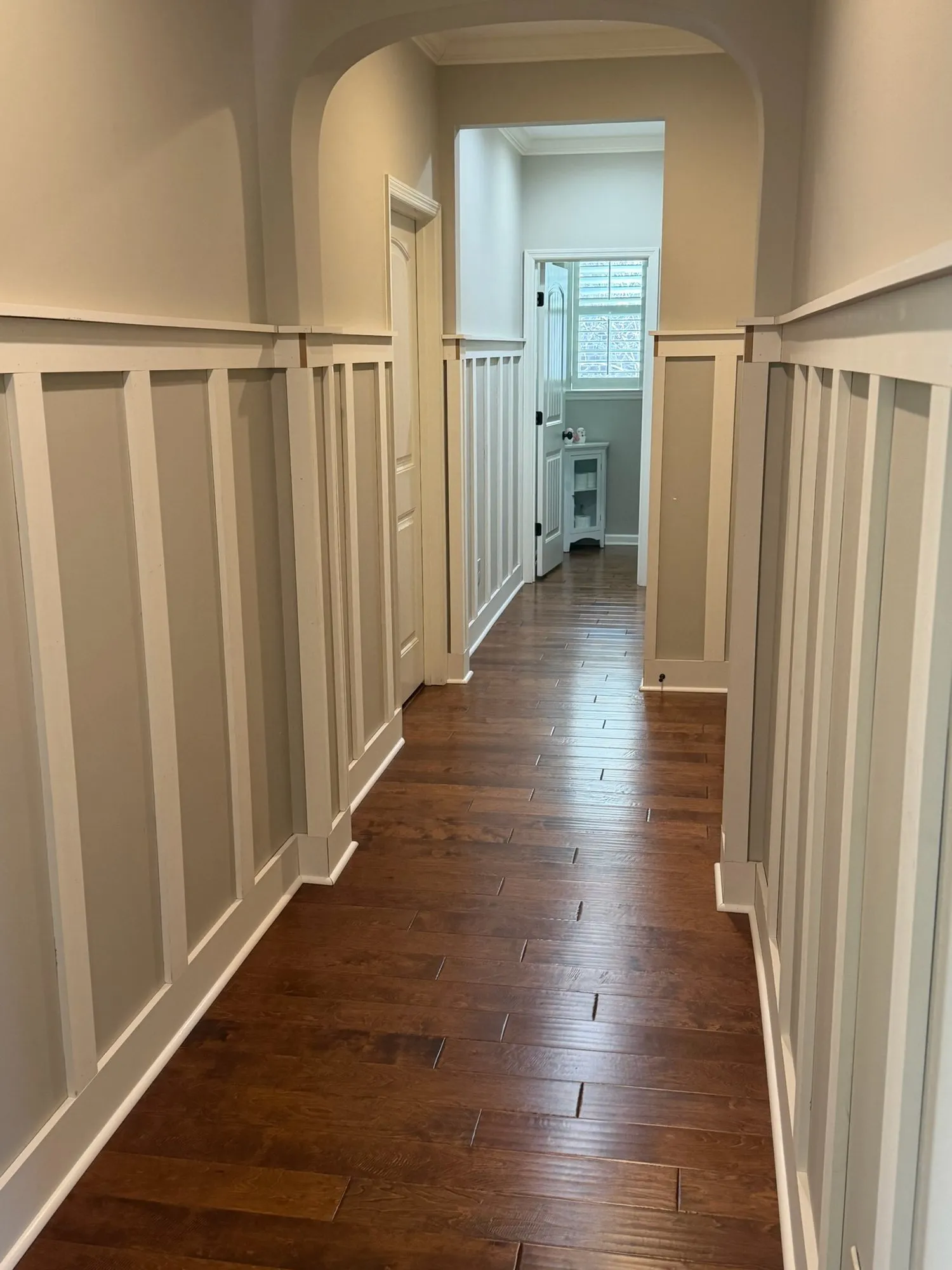 Board and batten hallway with arched openings